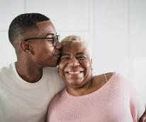 senior woman and her son are smiling while he is kissing her after she god senor home care from Stay at Home Homecare Agency in Philadelphia, PA