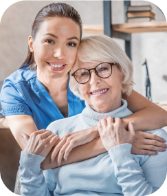 senior lady with glasses and Stay At Home homecare employee are happy and hugging and smiling